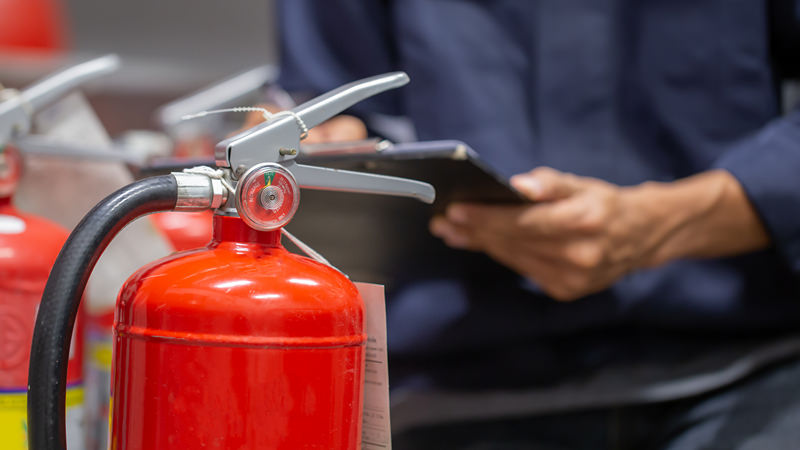 Engineer are checking and inspection a fire extinguishers tank in the fire control room for safety training and fire prevention.